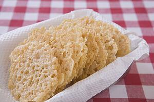 parmesan cheese laces in a basket on a red checkered table cloth