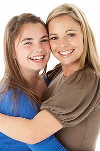 Studio Portrait Of Mother Hugging Daughter