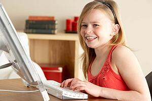 Young Girl Using Computer At Home