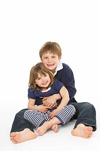 Studio Portrait Of Happy Brother And Sister