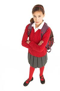 Studio Portrait Of Female Student In Uniform With Backpack