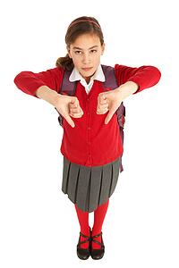 Studio Portrait Of Female Student In Uniform With Backpack