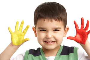 Studio Portrait Of Young Boy With Painted Hands