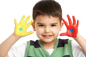 Studio Portrait Of Young Boy With Painted Hands