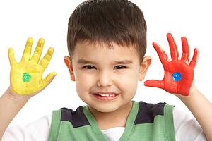 Studio Portrait Of Young Boy With Painted Hands