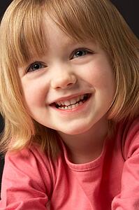 Close Up Studio Portrait Of Smiling Young Girl