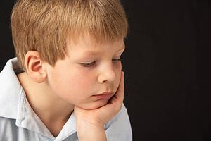 Studio Portrait Of Thoughtful Young Boy
