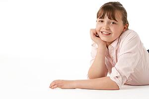 Young Girl Lying On Stomach In Studio