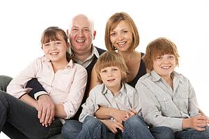 Studio Shot Of Family Group Sitting In Studio