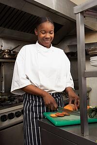 Female Chef Preparing Vegetables In Restaurant Kitchen