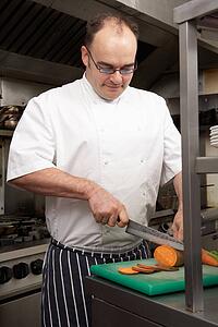 Male Chef Preparing Vegetables In Restaurant Kitchen