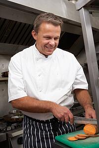 Male Chef Preparing Vegetables In Restaurant Kitchen