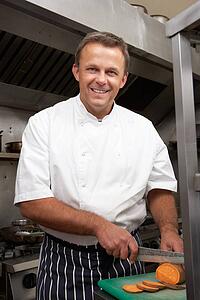 Male Chef Preparing Vegetables In Restaurant Kitchen