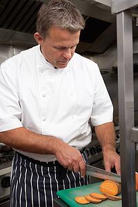 Male Chef Preparing Vegetables In Restaurant Kitchen