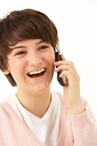 Studio Portrait Of Young Girl Using Mobile Phone