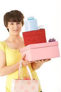 Studio Portrait Of Teenage Girl Carrying Packages And Shopping Bags
