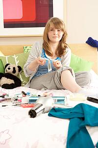 Teenage Girl In Untidy Bedroom Waxing Legs