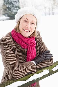 Senior Woman Standing Outside In Snowy Landscape