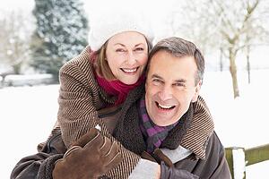 Senior Couple Standing Outside In Snowy Landscape