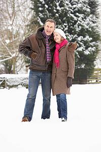 Senior Couple Walking In Snowy Landscape