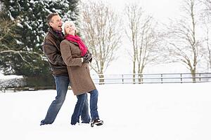 Senior Couple Walking In Snowy Landscape