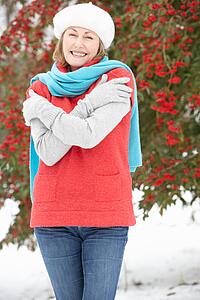 Senior Woman Standing Outside In Snowy Landscape
