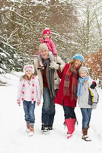 Family Walking Through Snowy Woodland