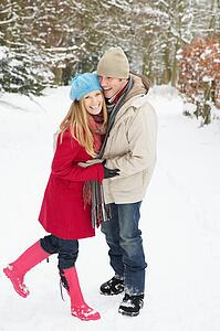 Couple Walking Through Snowy Woodland