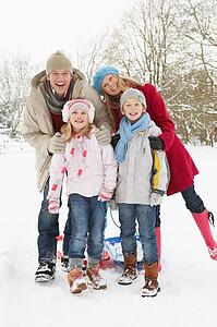 Family Pulling Sledge Through Snowy Landscape