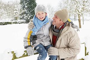 Father And Son Standing Outside In Snowy Landscape