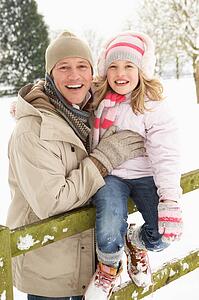 Father And Daughter Standing Outside In Snowy Landscape