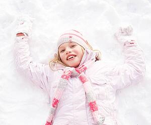Girl Laying On Ground Making Snow Angel
