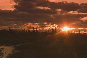 alberta, canada; silhouette of trees along the elbow river valley at sunset