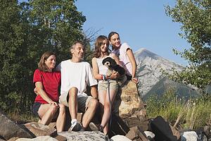 kananaskis country, alberta, canada; a family sitting on the rocks in the mountains with their dog