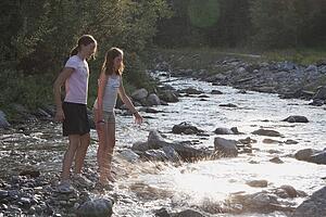 kananaskis country, alberta, canada; two girls throwing rocks into the river