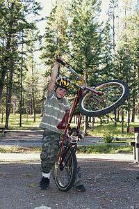 banff national park, alberta, canada; a boy plays with his bike in a campground