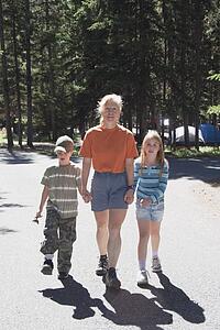 banff national park, alberta, canada; a woman walks with a boy and girl in a campground