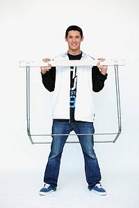 a boy standing inside the metal frame of a barrier