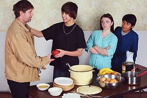 teenagers serving a meal to a man