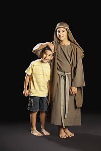 a young boy dressed up as jesus embracing another boy