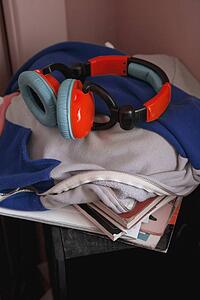earphones on top of a pile of books and clothing
