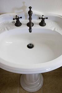 a white bathroom pedestal sink