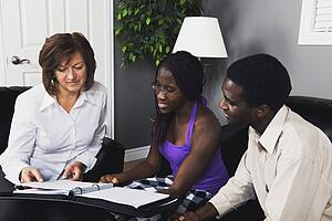 a businesswoman showing a document to a couple