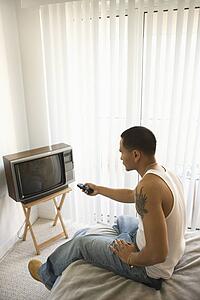 Young Man Turning on TV