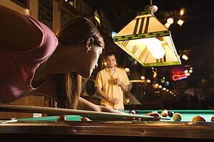 Young Woman Shooting Pool
