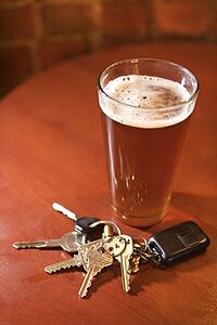 Glass of Beer and Keys on Bar Table