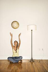 Young Woman Smiling and Sitting Tossing a Globe