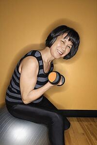 Woman on Balance Ball Lifting Weights
