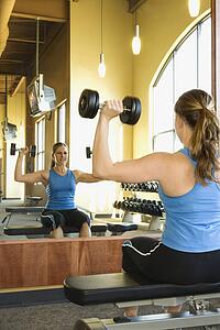 Woman Seated Lifting Weights