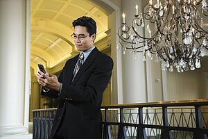 Businessman Checking Messages on Cellphone